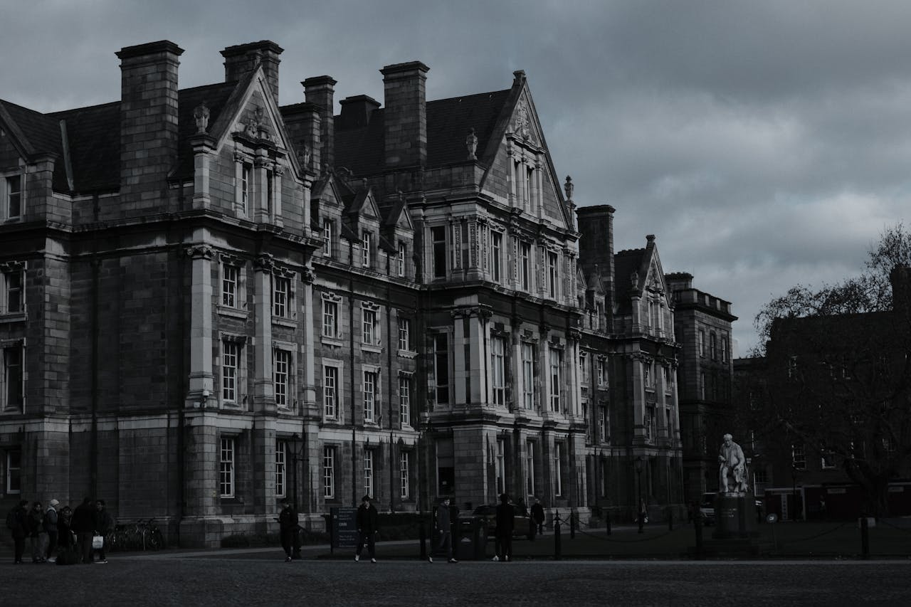 Gothic architecture of Trinity College, Dublin under moody clouds.